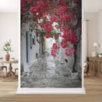 Fototapeta Bougainvillea rozzáří úzkou uličku.